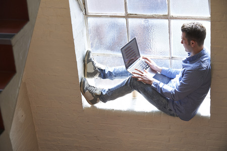 Casually Dressed Businessman Working On Stairs In Office