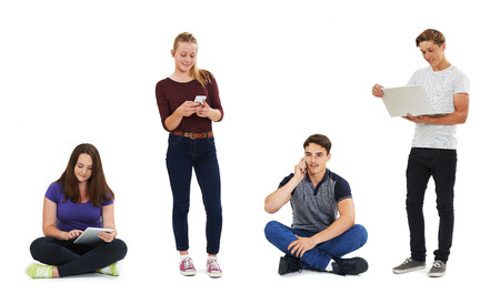 Studio Shot Of Teenagers Using Communication Technology