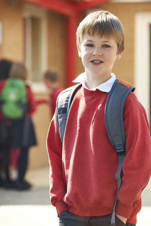 Boy Wearing Uniform Standing In School Playgroundの写真素材