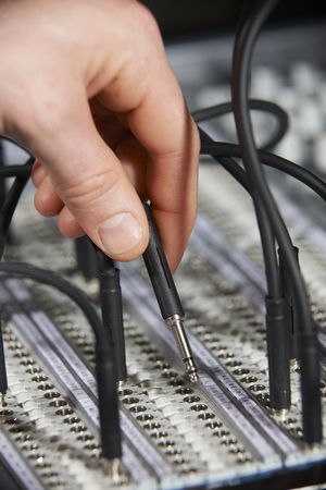 Engineer Plugging Cable Into Patch Panel