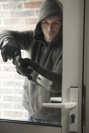 Burglar Using Crowbar To Break Into Houseの写真素材