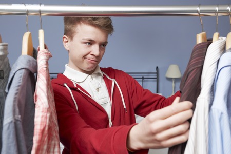 Teenage Boy Choosing Clothes From Wardrobeの写真素材