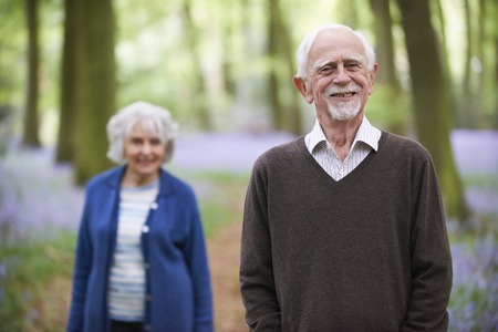 Senior Couple Walking Through Bluebells Woodsの写真素材