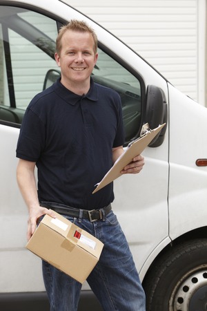 Courier Delivering Package Standing Next To Van