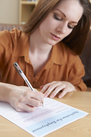 Young Woman Completing Employment Application Formの写真素材