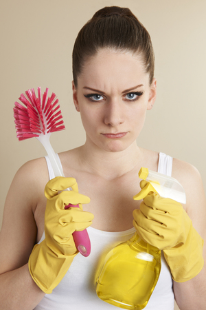 Young Woman Holding Cleaning Products Looking Unhappyの写真素材