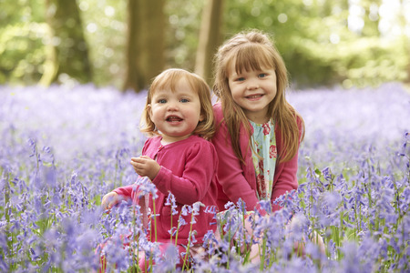 Two Girls Sitting In Bluebell Woods Togetherの写真素材