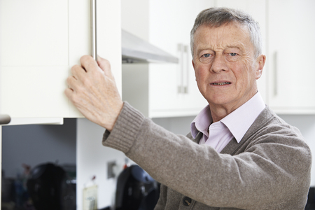 Forgetful Senior Man Looking In Cupboardの写真素材