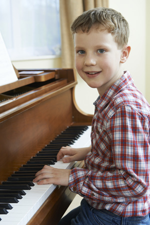 Portrait Of Young Boy Playing Piano At Homeの写真素材