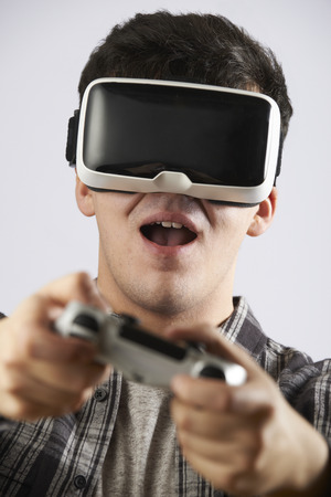 Man Playing Video Game Wearing Virtual Reality Headsetの写真素材
