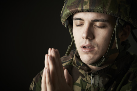 Studio Portrait Of Soldier In Uniform Praying
