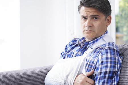 Portrait Of Mature Man With Arm In Sling At Homeの写真素材