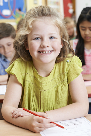 Portrait Of Female Elementary School Pupil Working At Deskの写真素材