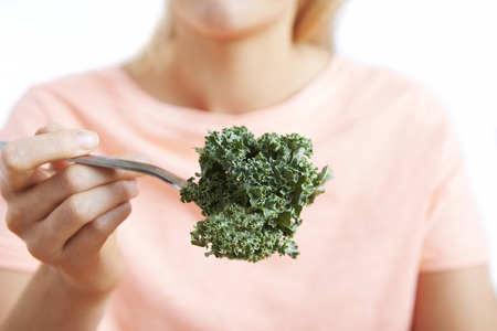 Close Up Of Woman With Kale On Forkの写真素材