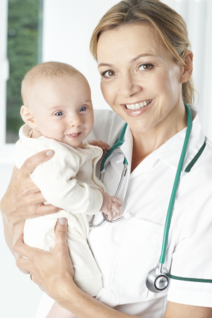 Portrait Of Nurse Holding Baby Girlの写真素材