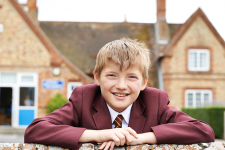 Portrait Of Boy In Uniform Outside School Building