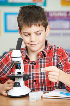 Male Pupil Using Microscope In Science Lessonの写真素材