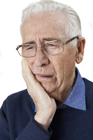 Studio Portrait Of Senior Man Suffering With Toothacheの写真素材