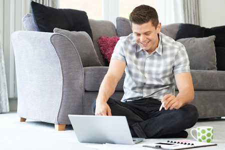 Male Freelance Worker Using Laptop At Homeの写真素材