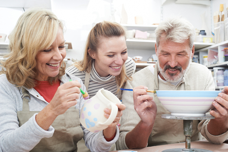 Mature Couple With Teacher In Pottery Classの写真素材