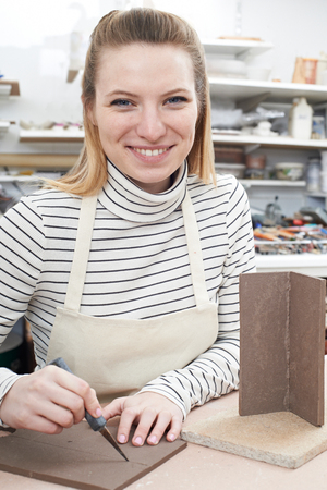 Portrait Of Young Woman Making Pot in Ceramics Studioの写真素材