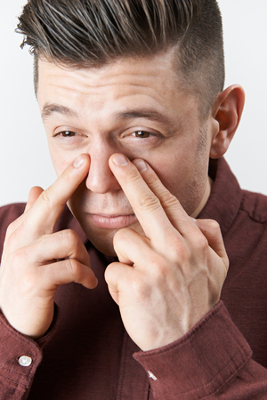 Studio Shot Of Man Suffering With Sinus Problemの写真素材
