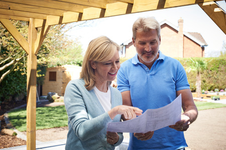 Mature Woman Looking At Design Plan With Landscape Gardenerの写真素材