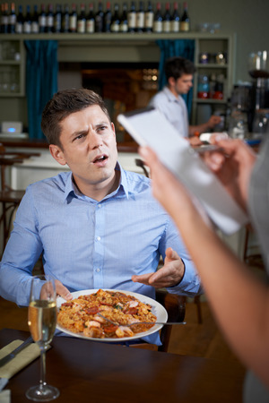 Customer In Restaurant Complaining To Waitress About Foodの写真素材