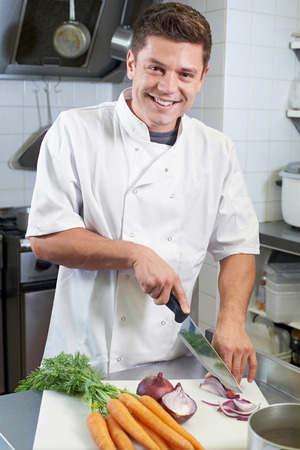 Portrait Of Chef Preparing Vegetables In Restaurant Kitchenの写真素材