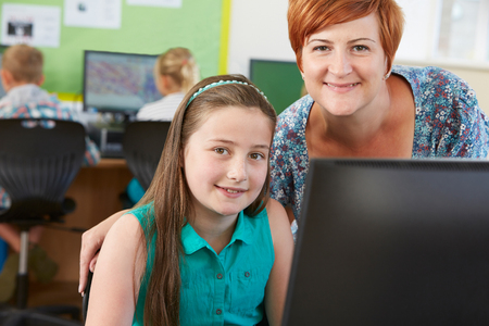Female Elementary Pupil In Computer Class With Teacherの写真素材