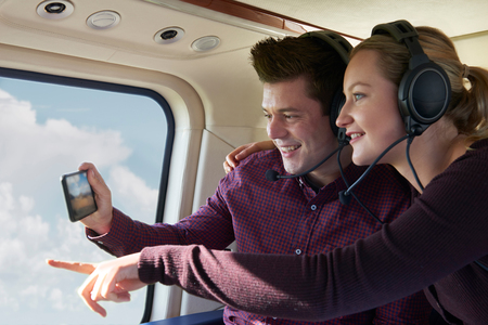 Couple On Vacation Taking Ride In Helicopterの写真素材