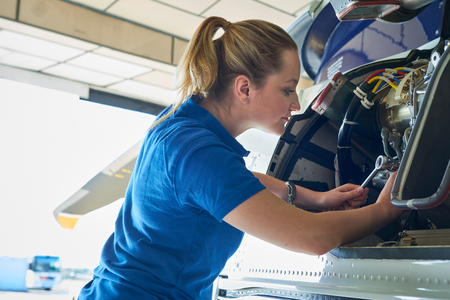 Female Aero Engineer Working On Helicopter In Hangarの写真素材