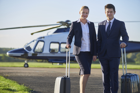 Portrait Of Businesswoman And Businessman Standing In Front Of Helicopter の写真素材