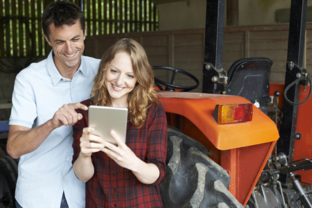 Male And Female Agricultural Workers Looking At Digital Tabletの写真素材