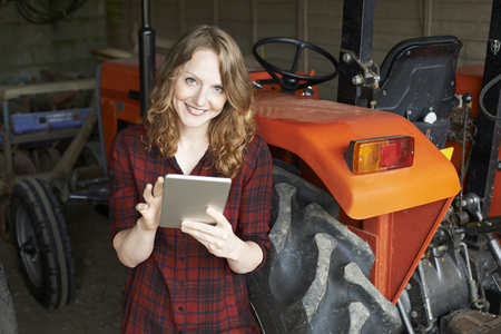 Portrait Of Female Agricultural Worker On Farm Using Digital Tabletの写真素材