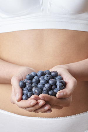 Close Up Of Woman In Underwear Holding Fresh Blueberriesの写真素材