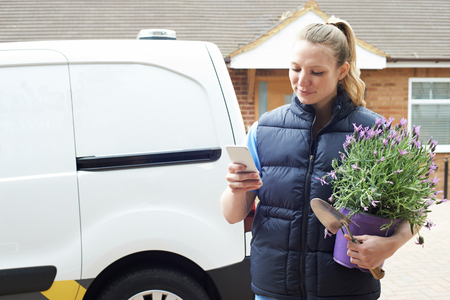 Woman Running Mobile Gardening Business Using Mobile Phoneの写真素材