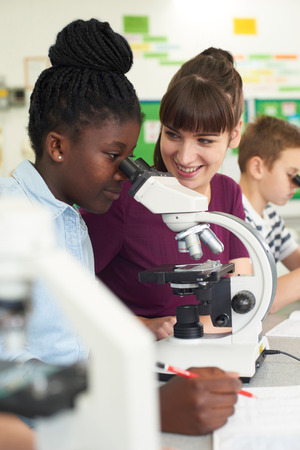 Group Of Pupils With Teacher Using Microscopes In Science Classの写真素材