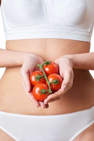Close Up Of Woman In Underwear Holding Tomatoesの写真素材