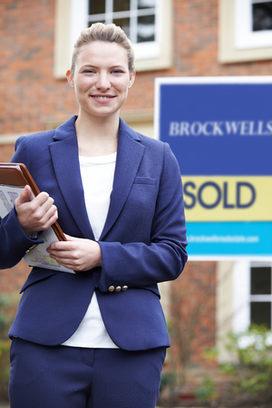 Portrait Of Female Realtor Standing Outside Residential Propertyの写真素材