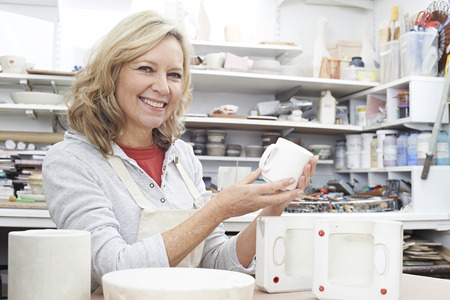 Portrait Of Mature Woman In Pottery Studio Casting Mugの写真素材