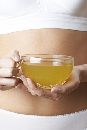 Close Up Of Woman Wearing Underwear Drinking Green Teaの写真素材