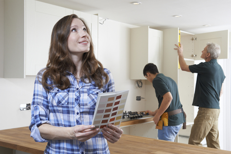 Woman Looking At Paint Chart In New Kitchenの写真素材