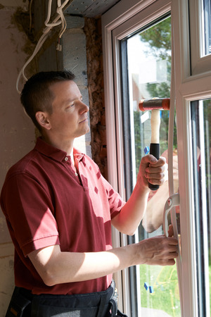 Construction Worker Installing New Windows In Houseの写真素材