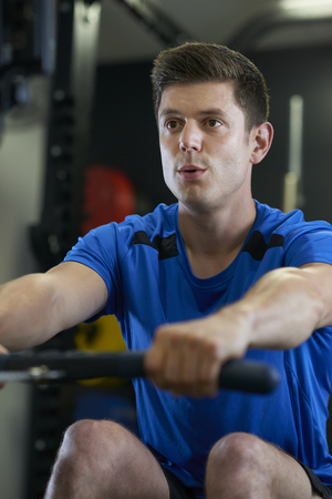 Man In Gym Exercising On Rowing Machineの写真素材