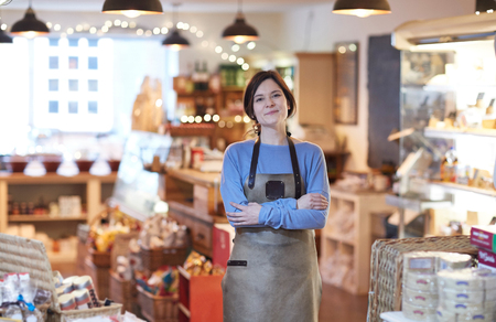 Portrait Of Smiling Female Owner Of Delicatessen Shop Wearing Apronの写真素材