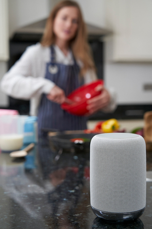 Woman Preparing Meal At Home Asking Digital Assistant Questionの写真素材