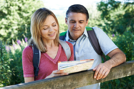 Mature Couple Hiking In Countryside Looking At Mapの写真素材