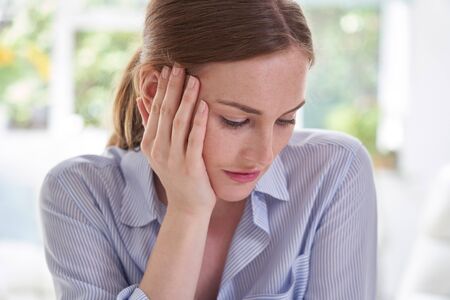 Sad Young Woman Suffering From Depression With Head In Handsの写真素材