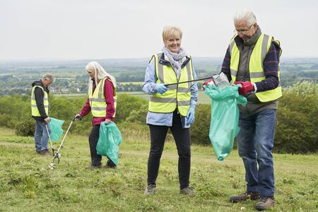 Group Of Helpful Seniors Collecting Litter In Countrysideの写真素材